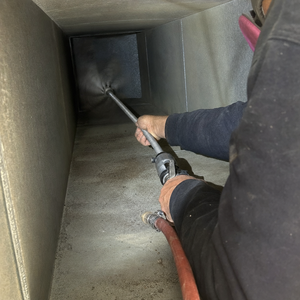 Technician using a pneumatic tool for professional air duct cleaning services